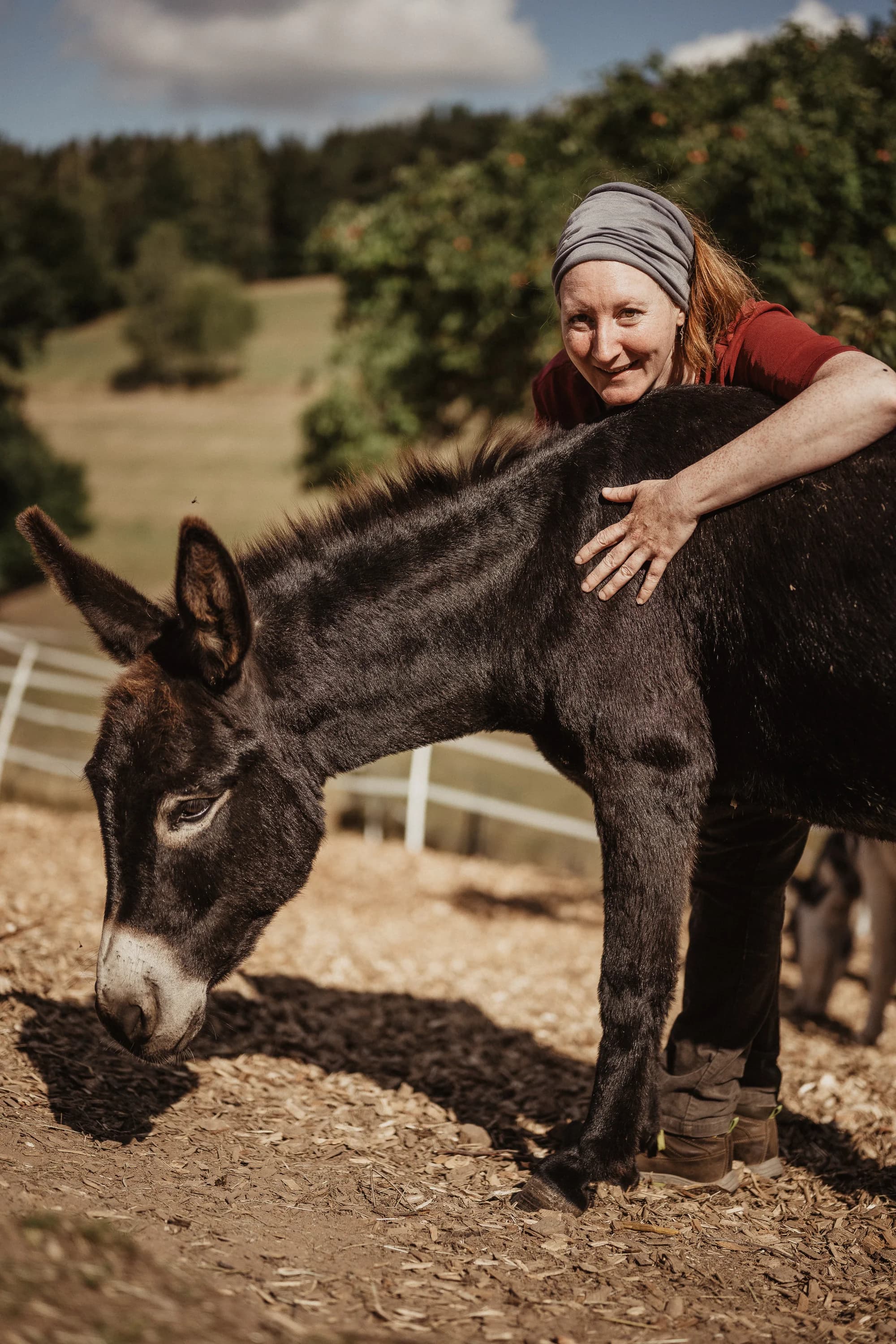 Sabine Kuhnert mit einem Esel vor den Hügeln der Rhön